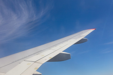 View from airplane window with blue sky and white clouds