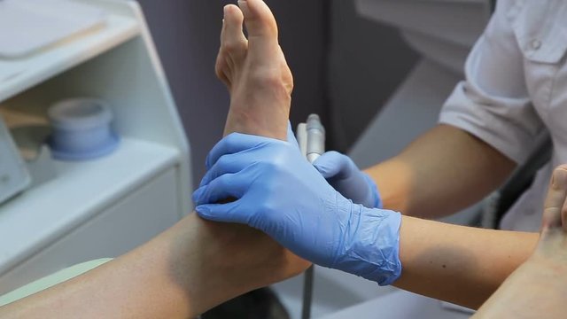 Woman gets a pedicure procedure in spa salon.Woman lying down receiving pedicure.Woman in a nail salon receiving treatment.The process of professional pedicure.Spa treatments, beauty center.