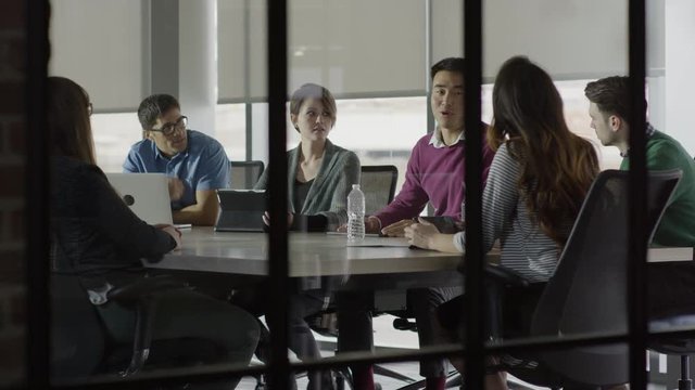 Medium shot of business people talking in meeting / Lehi, Utah, United States