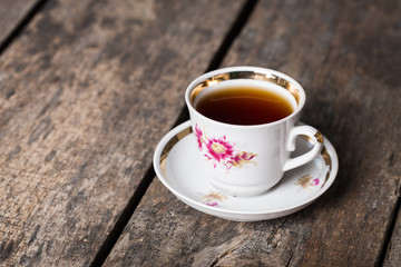 Closeup of cup of tea on vintage wooden background