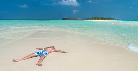 Fototapeta na wymiar Man is relaxing on a maldivian beach