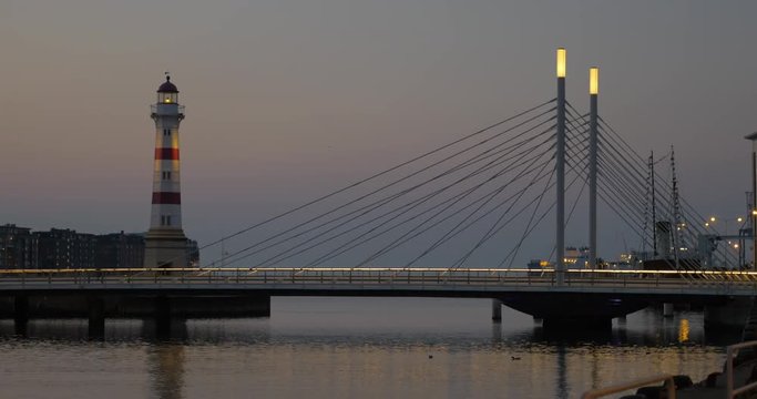 Evening cityscape with lit lighthouse and bridge over the river near the dockyard. Malmo, Sweden