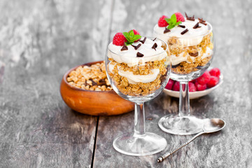 Granola  with cream and fresh raspberries in a glass