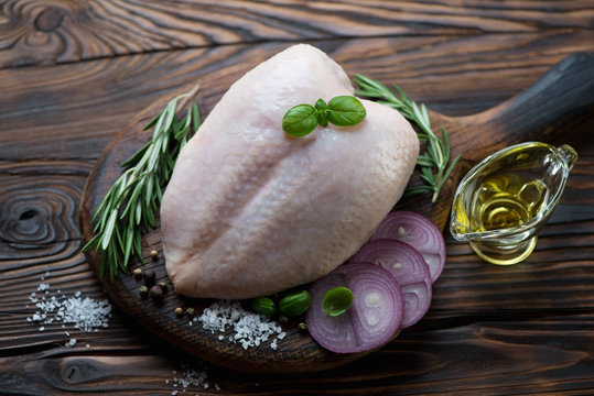 Fresh whole chicken breast with cooking ingredients, studio shot