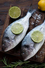 Two fresh uncooked seasoned sea breams, selective focus