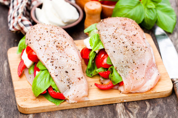 Raw  chicken breasts stuffed with mozzarella and vegetables