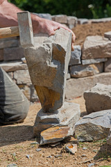 Maurer beim Behauen von Naturstein