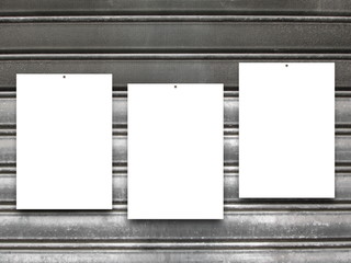 Close-up of three nailed blank frames on gray rusty metal shutter background