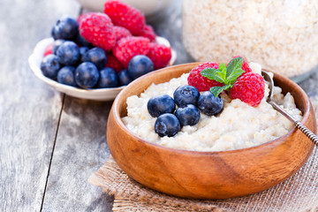 Porridge  in a wooden bowl with berries