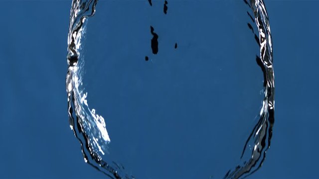 Sheet of water descending in ultra-slow motion and narrowing to center of frame