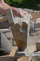Maurer beim Behauen von Naturstein