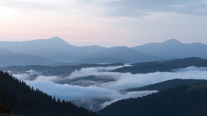 scenic view of mountain forests covering by fog