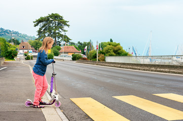 Pretty little girl is going to cross the road alone