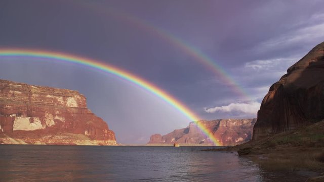 Wide shot of double rainbow over ocean / Lake Powell, Utah, United States