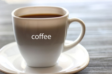 An espresso coffee in a white cup on a gray background