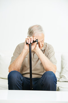 Senior mit Kr&uuml;ckstock ist traurig