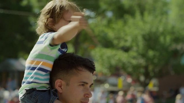 Medium slow motion shot of boy waving American flag at parade / American Fork, Utah, United States