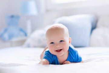 Baby boy in white sunny bedroom