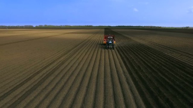 An Aerial View of a Tractor Planting Potatoes in the Fertile Fields of the Farm in the Spring.The Introduction of Fungicides