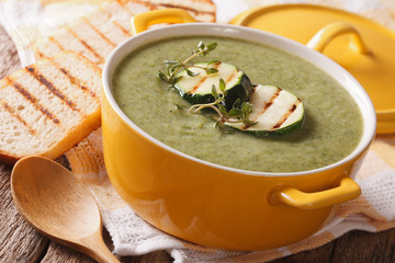 Zucchini soup puree in a close-up yellow saucepan and toast. horizontal
