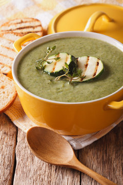 Summer Zucchini soup with thyme close-up in a saucepan. vertical
