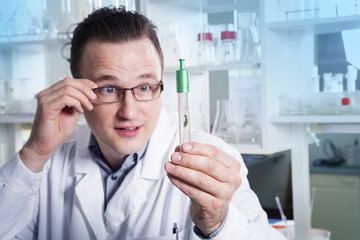 Lab worker in glasses observing test tube with mold at the laboratory