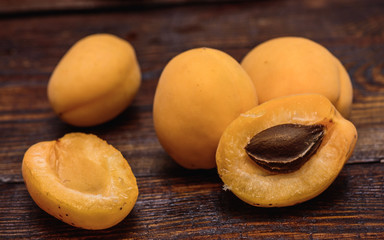 Fototapeta na wymiar half of apricot on dark wooden table