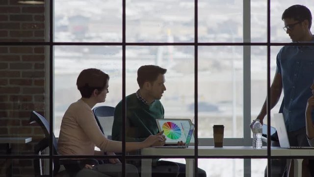 Medium panning shot of business people talking in meeting / Lehi, Utah, United States