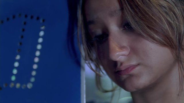 Close-up of troubled teenage girl at phone booth