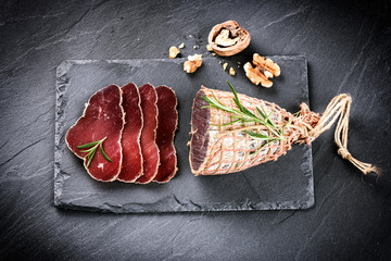 Gourmet dinner concept with sliced dry meat and walnuts - 114734995