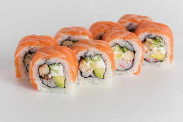 Sushi rolls with salmon, avocado and cheese on white background