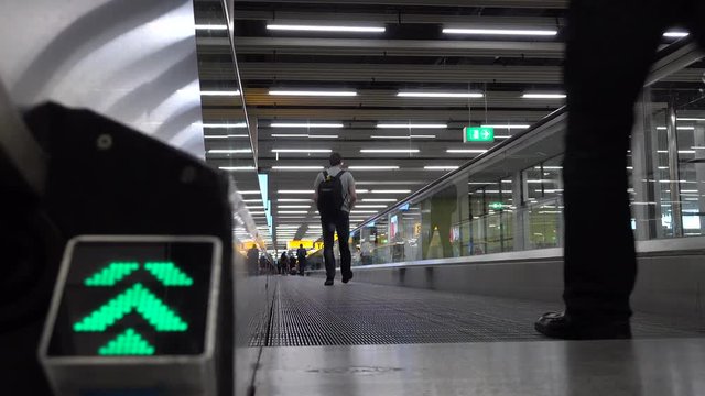 Passengers use horizontal airport escalator. Shot in 4K