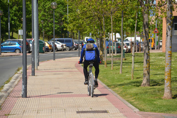 ciclista circulando por la acera de una calle