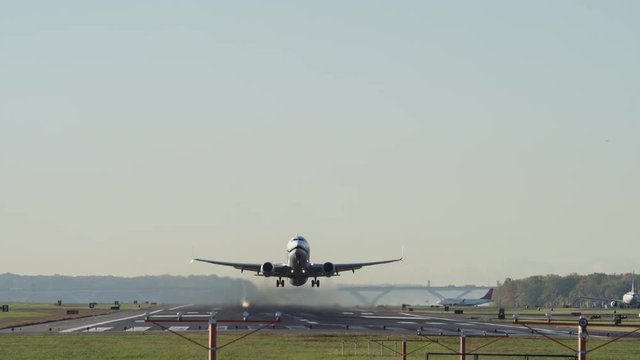 Wide low angle shot of airplane taking off from runway / Washington D.C., District of Columbia, United States