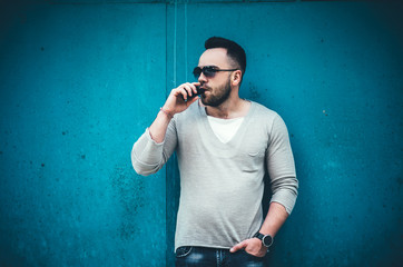 Vaper with beard in sunglasses vaping outdoor