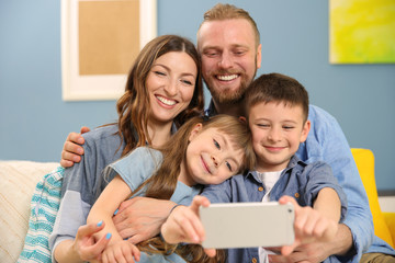 Happy family taking selfie on blue wall background