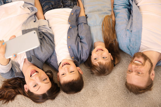 Happy family having selfie on the floor