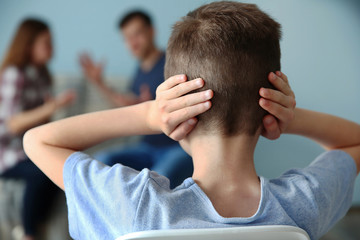 Family problems concept. Boy closing his ears while parents abusing