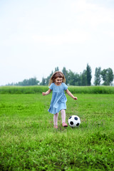 Little girl playing football outdoor