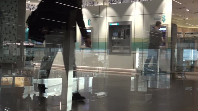 People use a cash machine  at the airport terminal. Shot in 4K