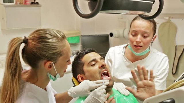 Portrait of doctor and frightened patient at dental clinic