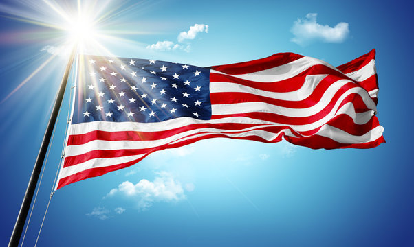 American flag in blue sky and sunshine background