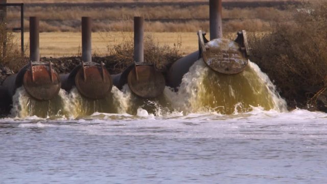 Pipes discharging greenish water into Tule Lake
