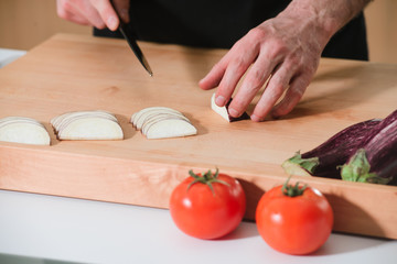 Closeup man's hands cutting vegetables in a kitchen