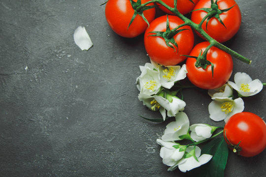 Fresh grape tomatoes and flowers for use as cooking ingredients with copyspace