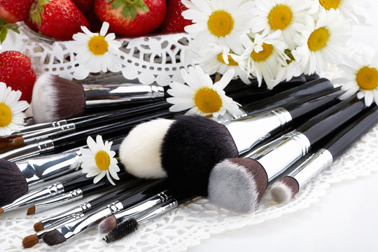 Set of makeup brushes with strawberries and flowers