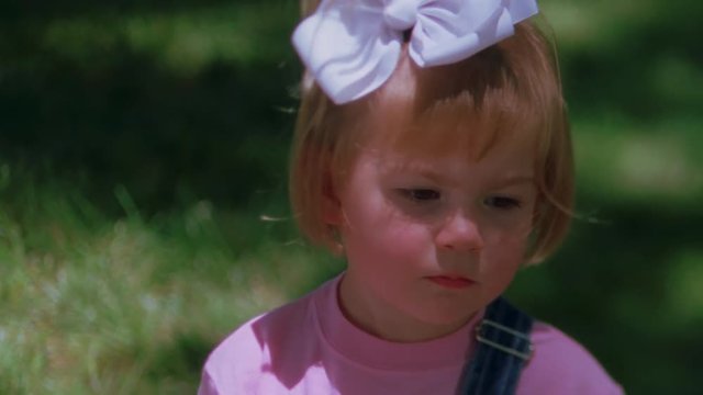 Close-up Of A Pouting Little Girl With A White Hair Bow