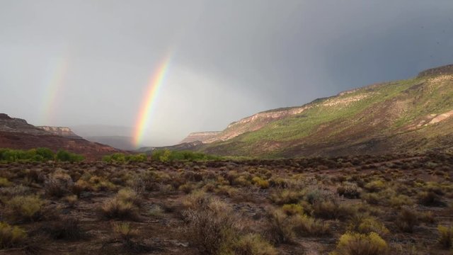 Pan across a desert valley with a rainbow
