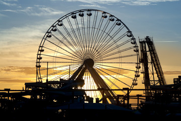 Ferris Wheel and roller coaster silhouette at sunset. Taken in Wildwood, New Jersey - obrazy, fototapety, plakaty