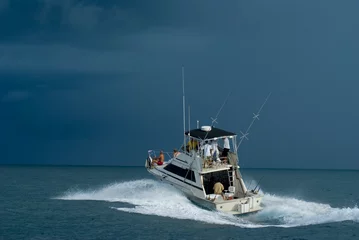Fototapeten Sport-Fischerboot, das sich auf den Weg macht, wenn sich ein Sturm nähert. © Aneese
